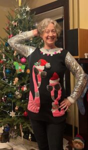 Jenny in a sweater with pink flamingos wearing Santa hats