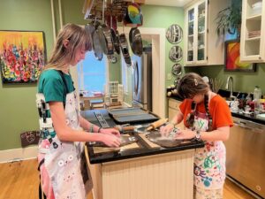 Amy and Sarah making gingerbread cookies at the kitchen island